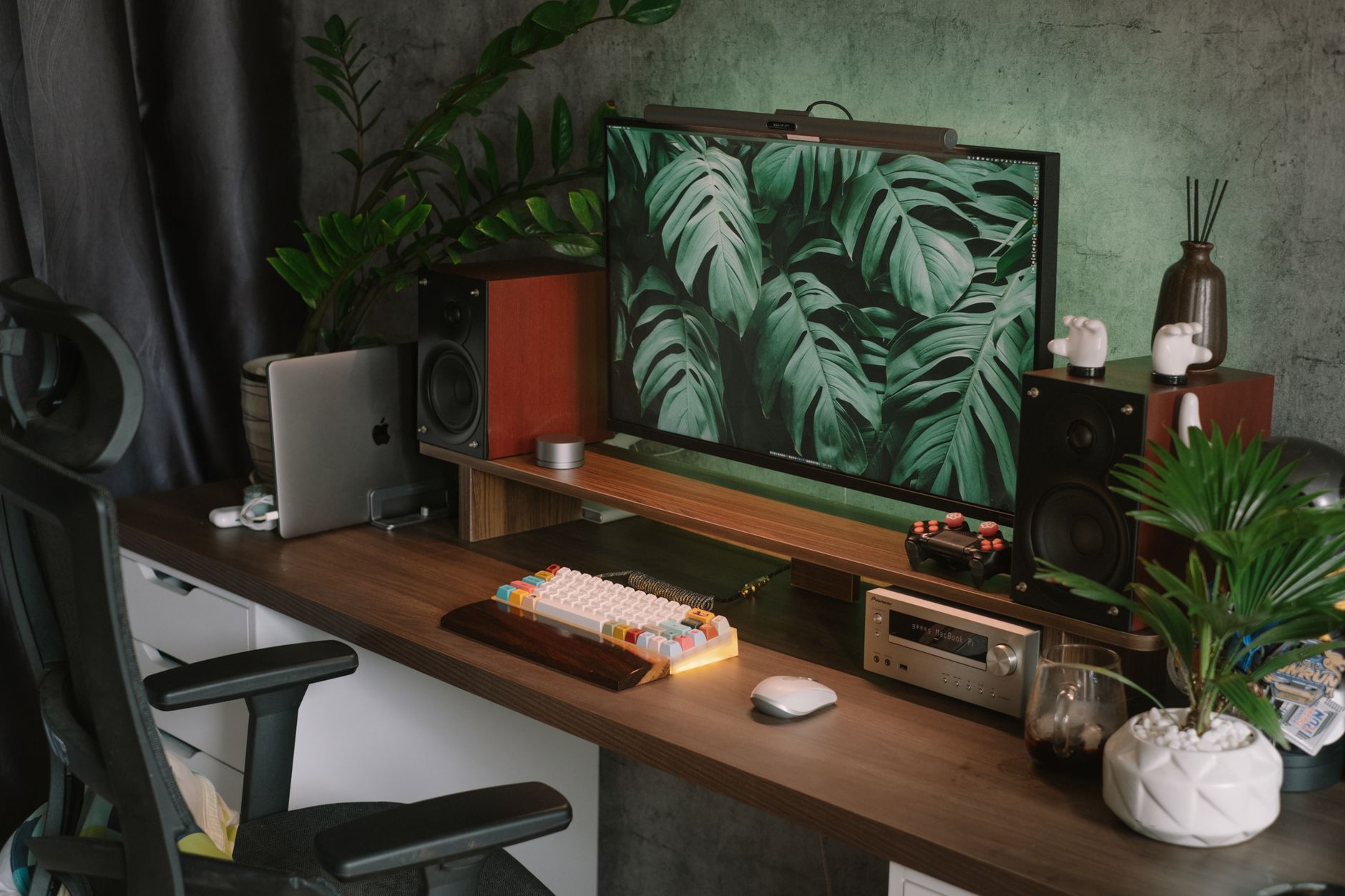 Bureau à domicile cosy avec un écran vintage, des plantes et du matériel moderne.