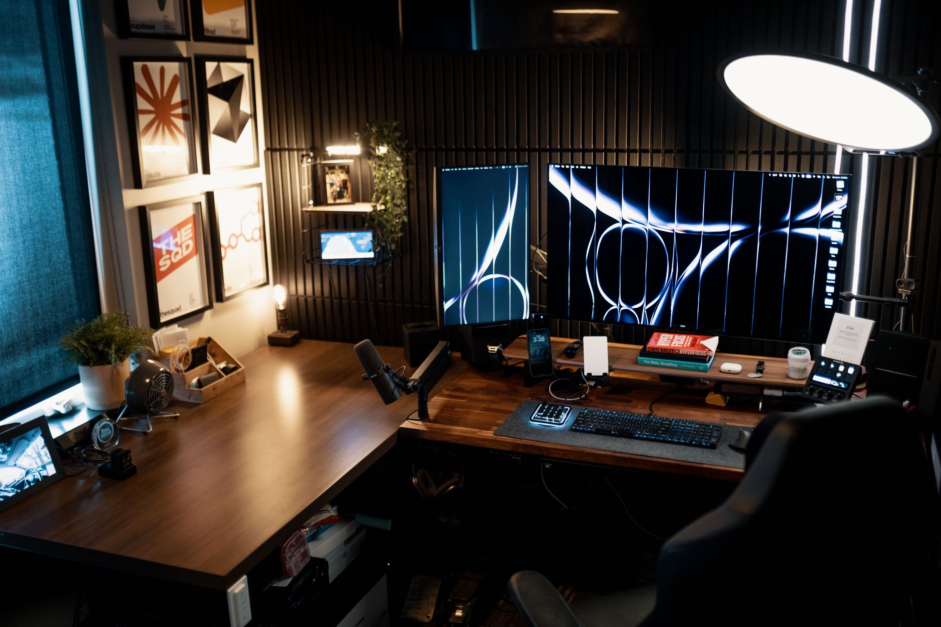 Bureau à domicile moderne et confortable avec deux écrans, une décoration soignée et un éclairage ambiant.